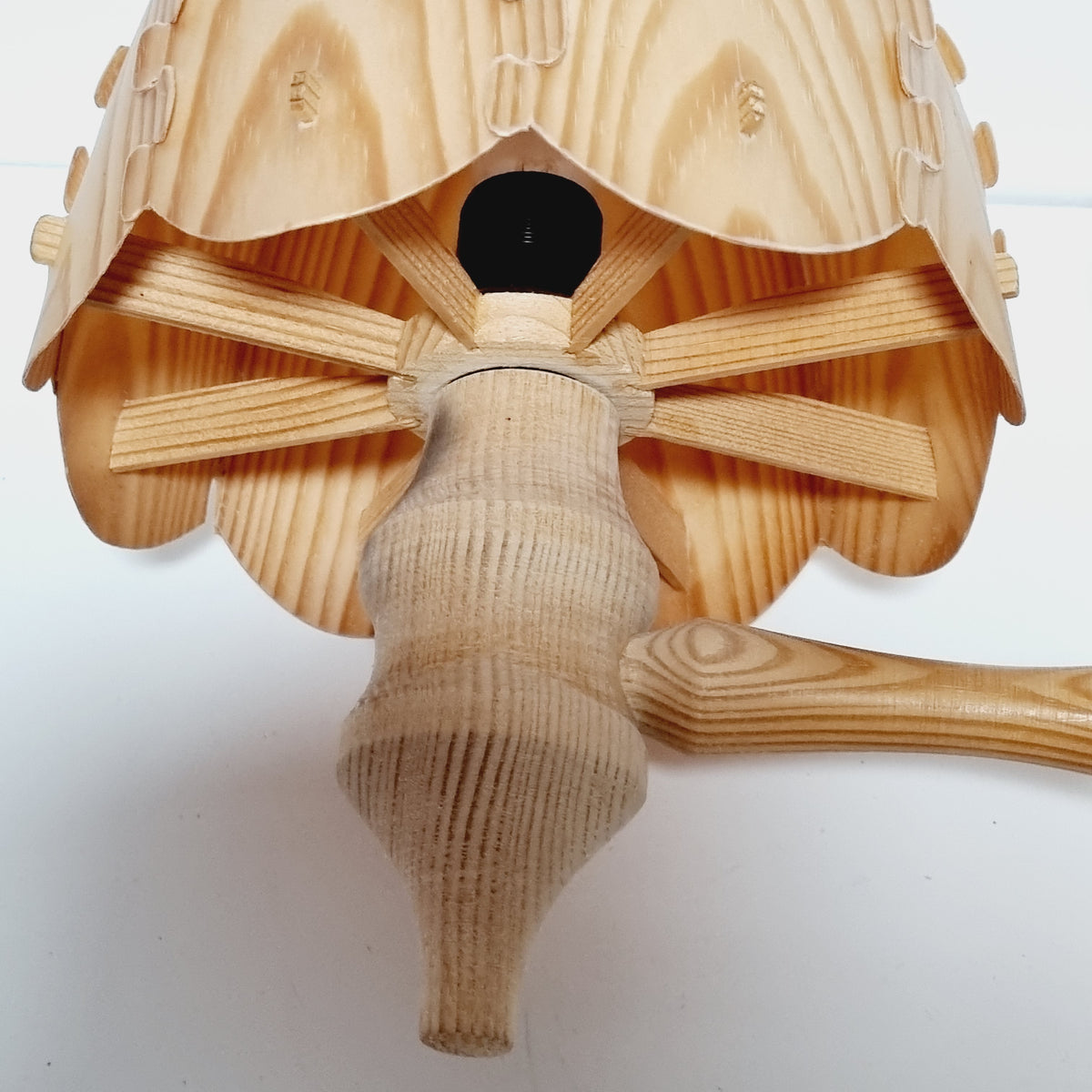 A wooden object with a curved shape and a spout-like design, possibly a piece of furniture or a decorative item.