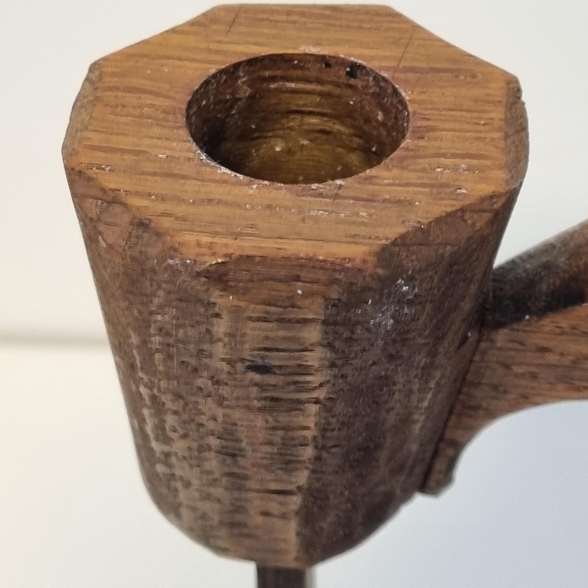 A close-up view of a wooden pipe with a hole in the center, showing the intricate details and texture of the wood.