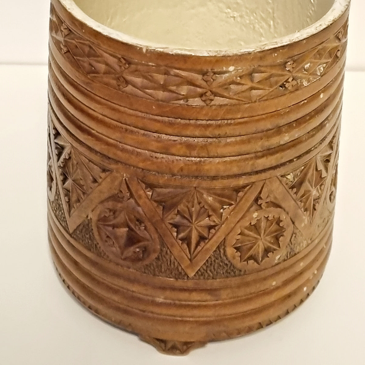 Star rosettes and diamond grid chip carving on antique wooden tankard