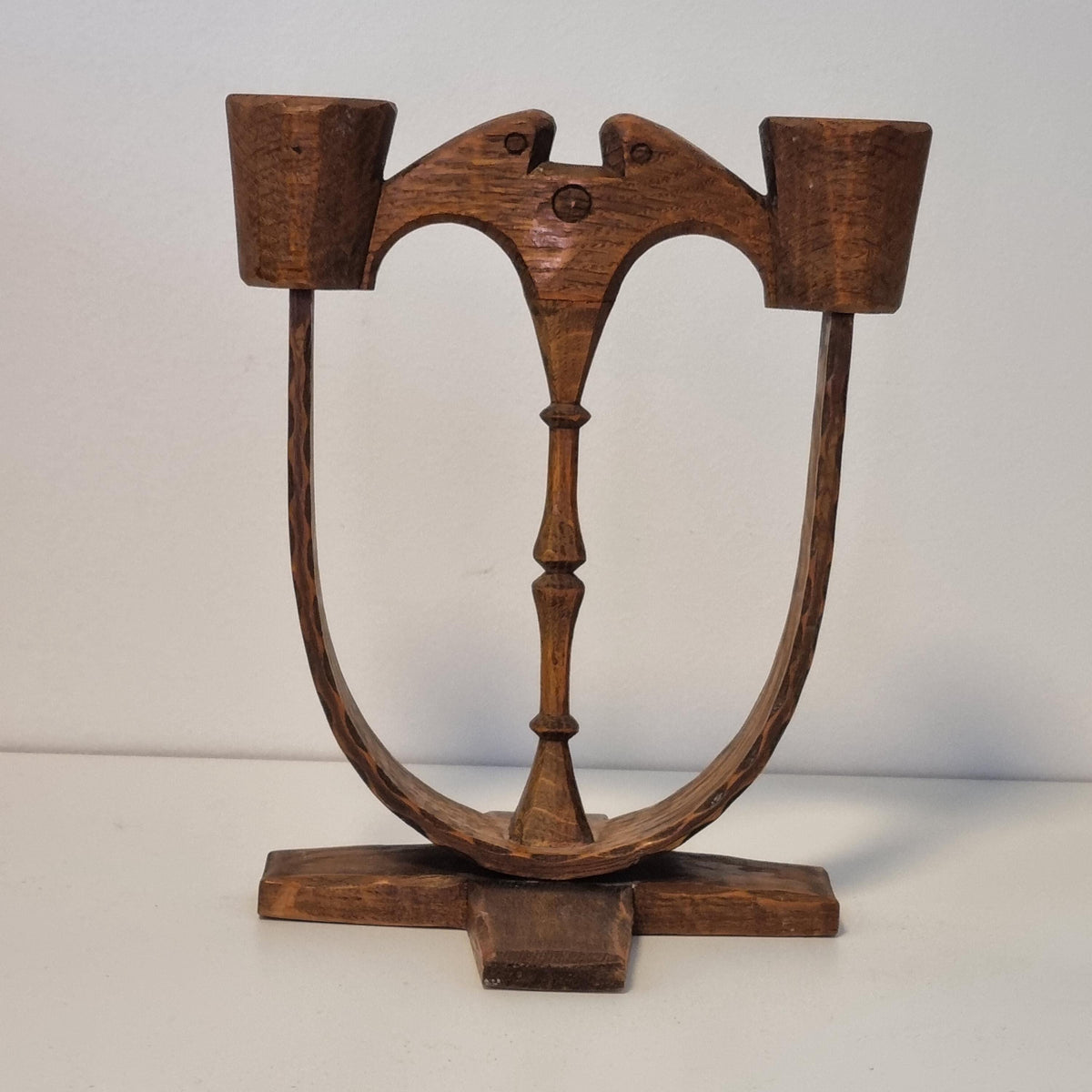 A wooden sculpture with a curved, organic shape and a dark finish.