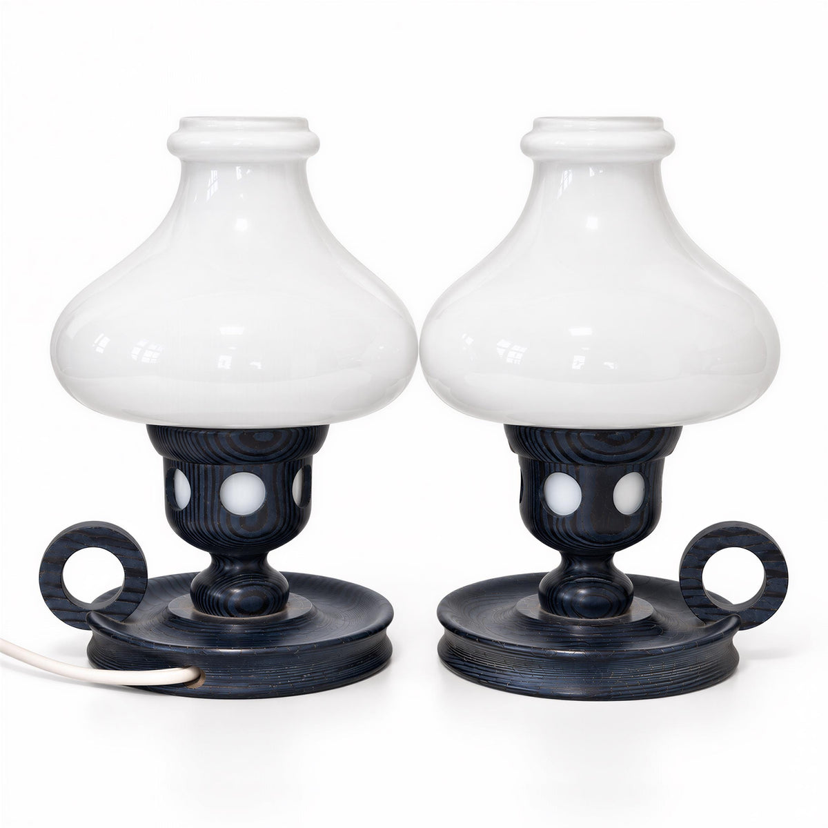 A pair of white lampshades with black bases and handles, placed side by side on a white background.