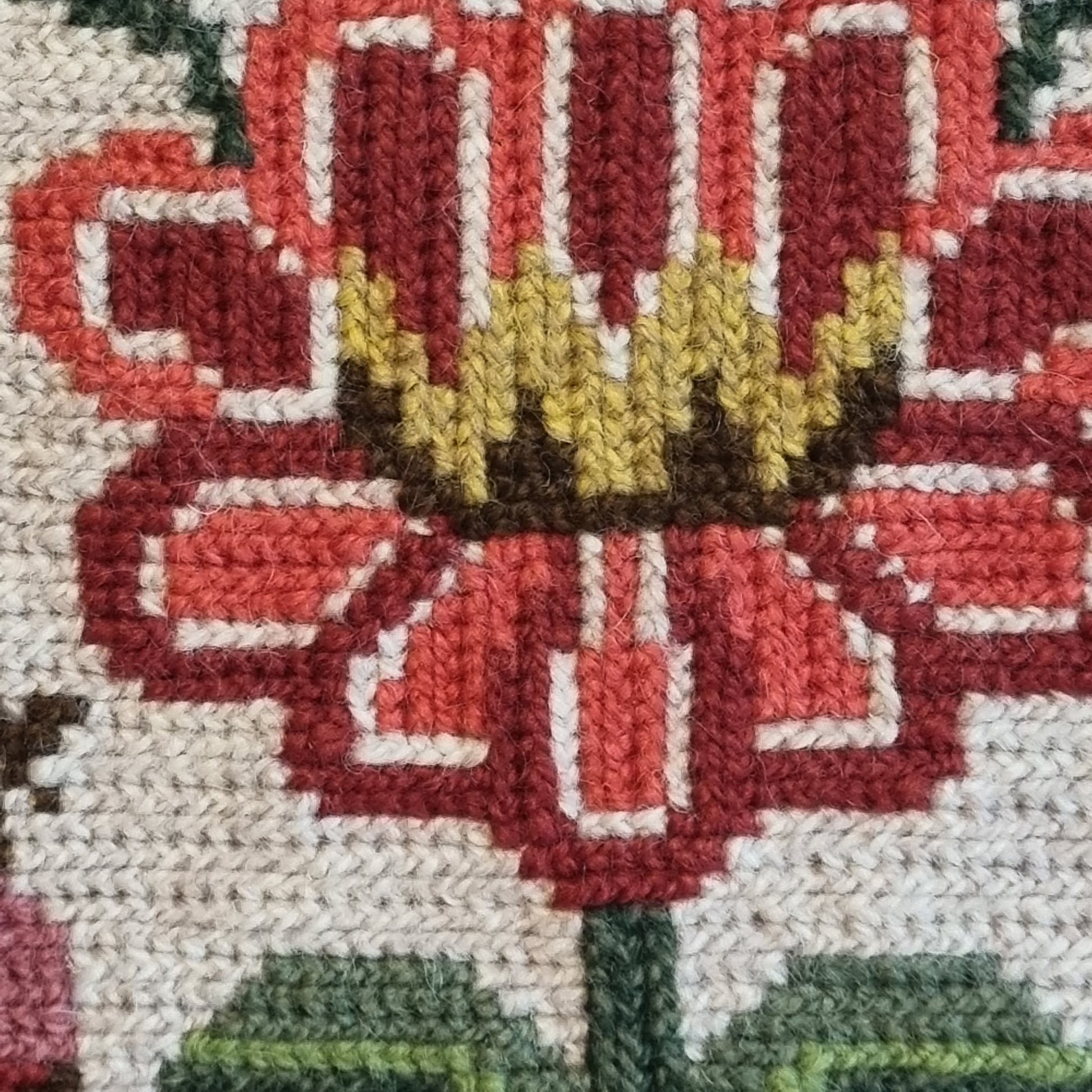 Close-up detail of facing birds and tulip motifs in red and navy on cream needlepoint ground