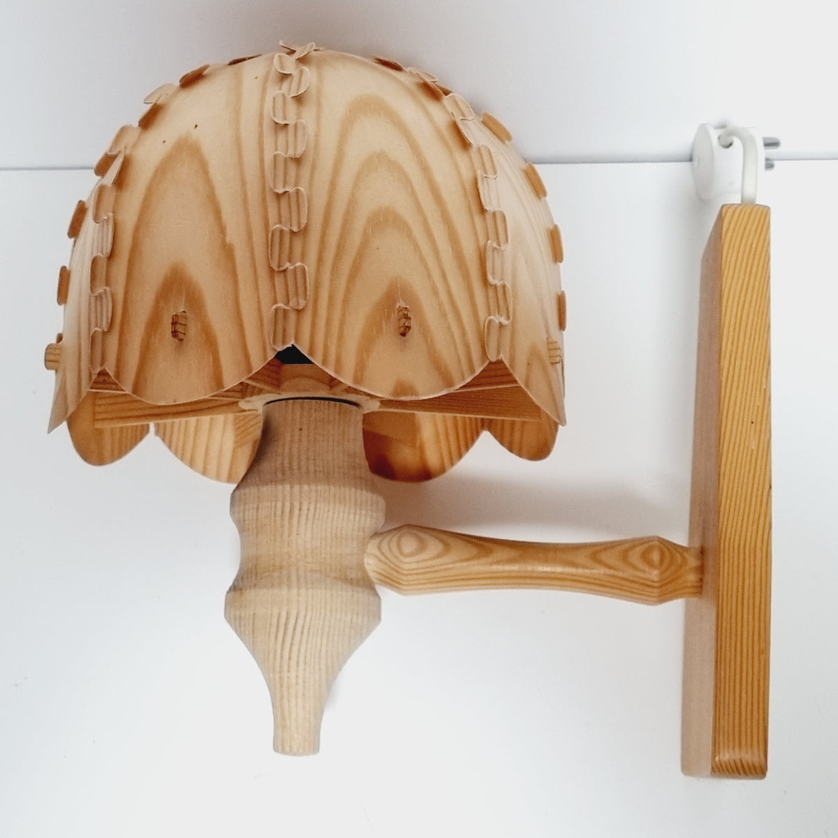 a wooden object with a curved shape, resembling a lamp or a light fixture.