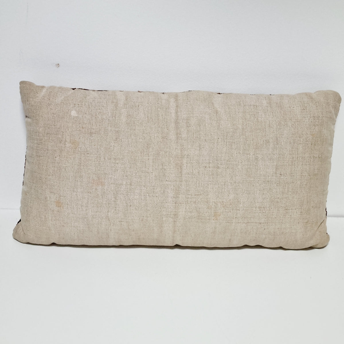 Plain beige fabric back of the vintage rectangular floral pillow