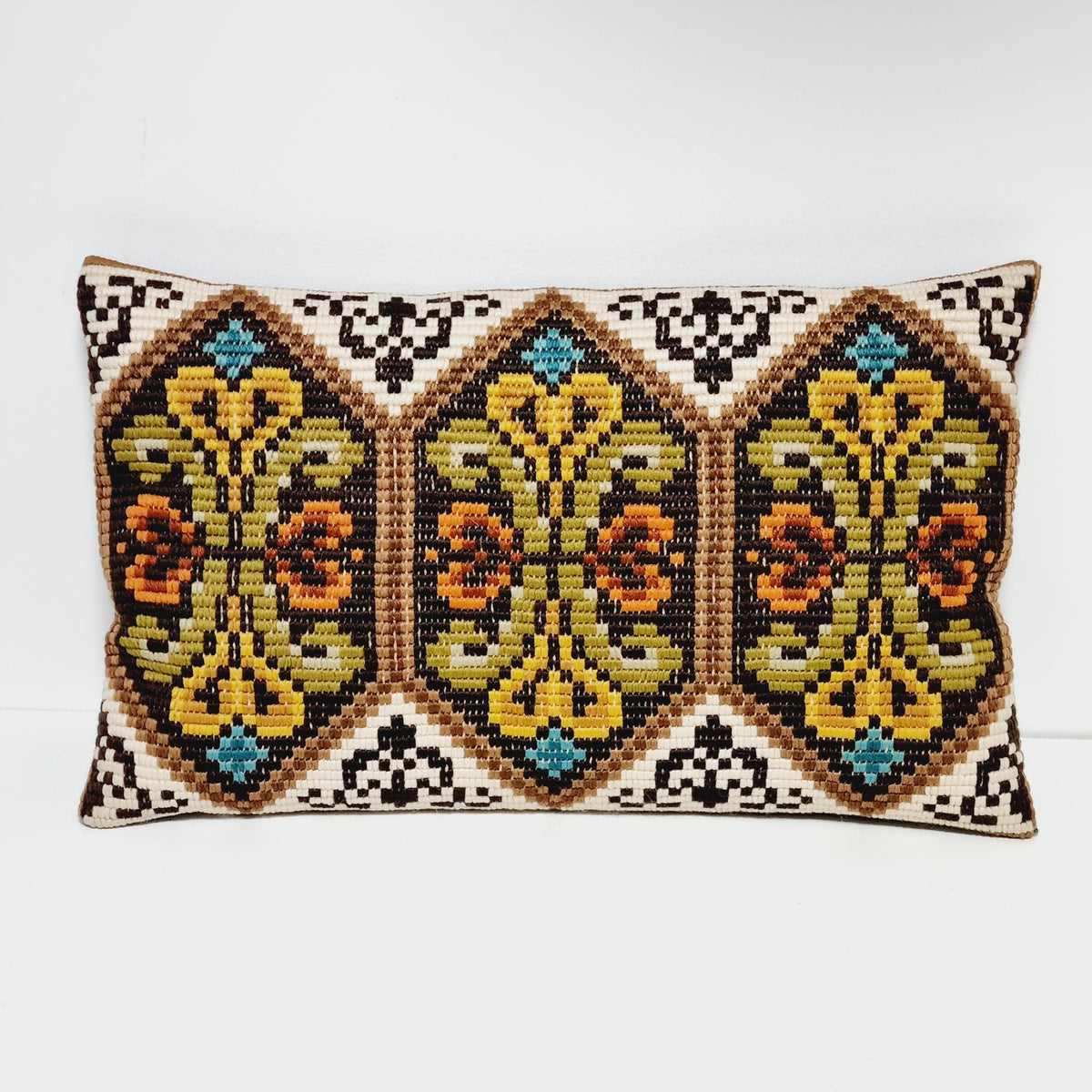 Rectangular vintage embroidered pillow with three floral panels in mustard, olive and orange with turquoise accents
