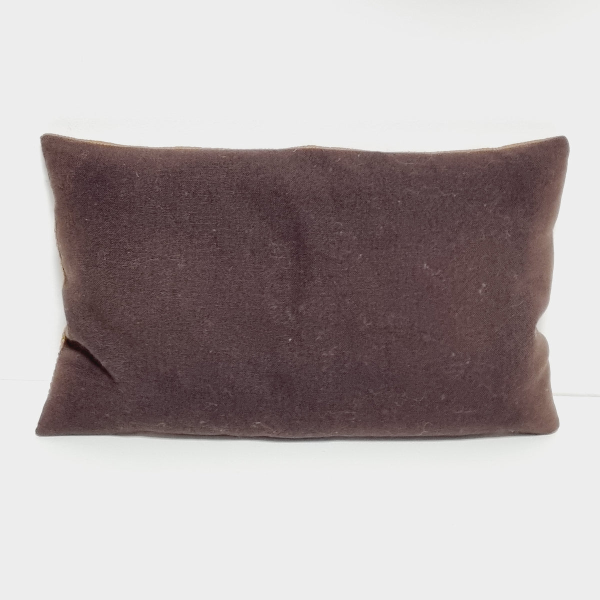 Plain brown fabric back of the rectangular vintage embroidered pillow