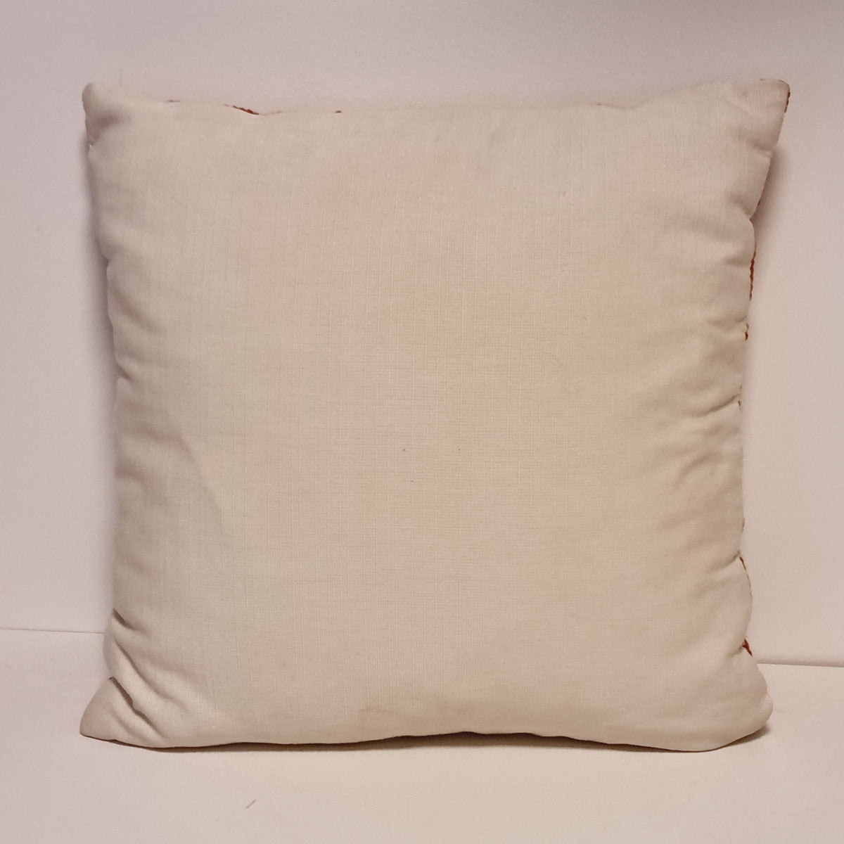 Plain cream back of the floral pillow showing the upper seam condition