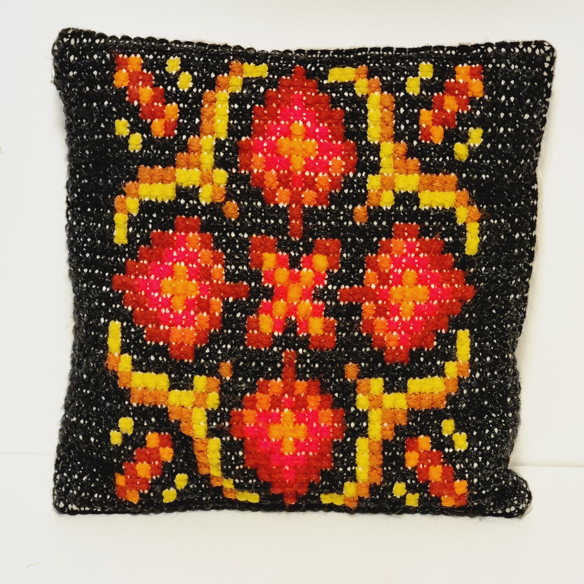 Vintage square embroidered pillow with red and orange geometric medallions on black and yellow accents