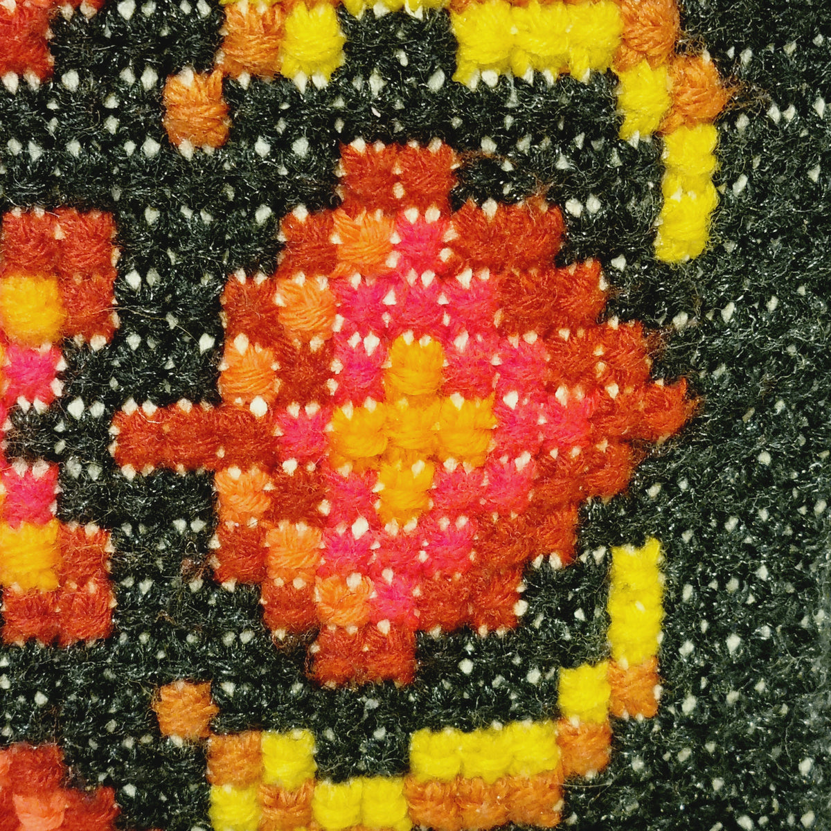 Close-up of the textured stitches and red medallion on the black background