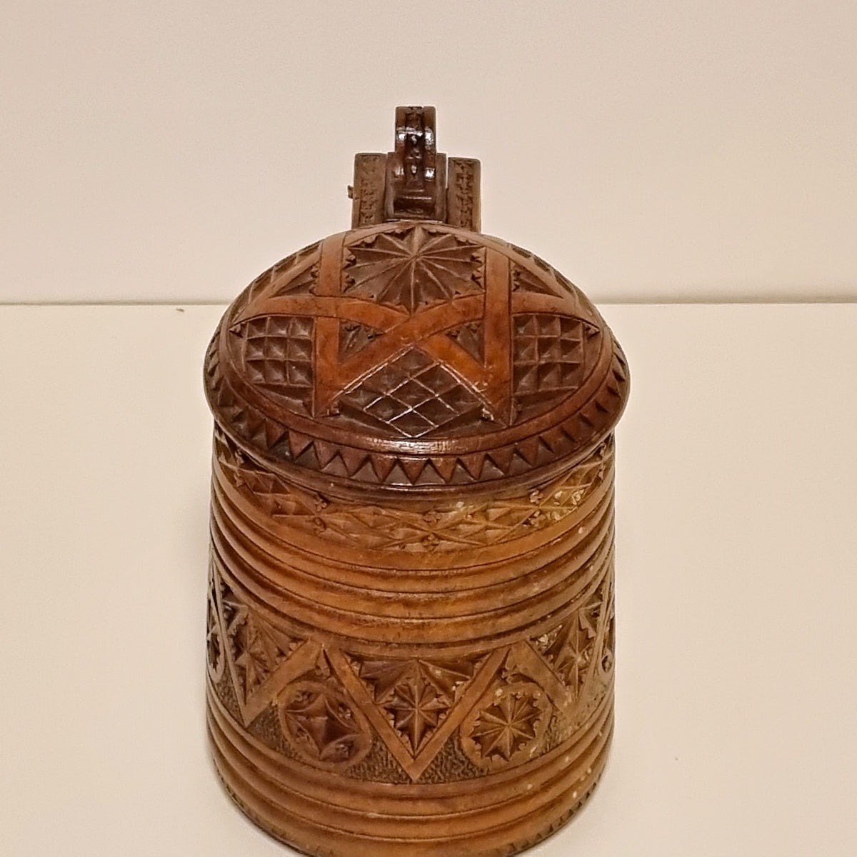 Front view of antique carved wooden tankard with domed lid