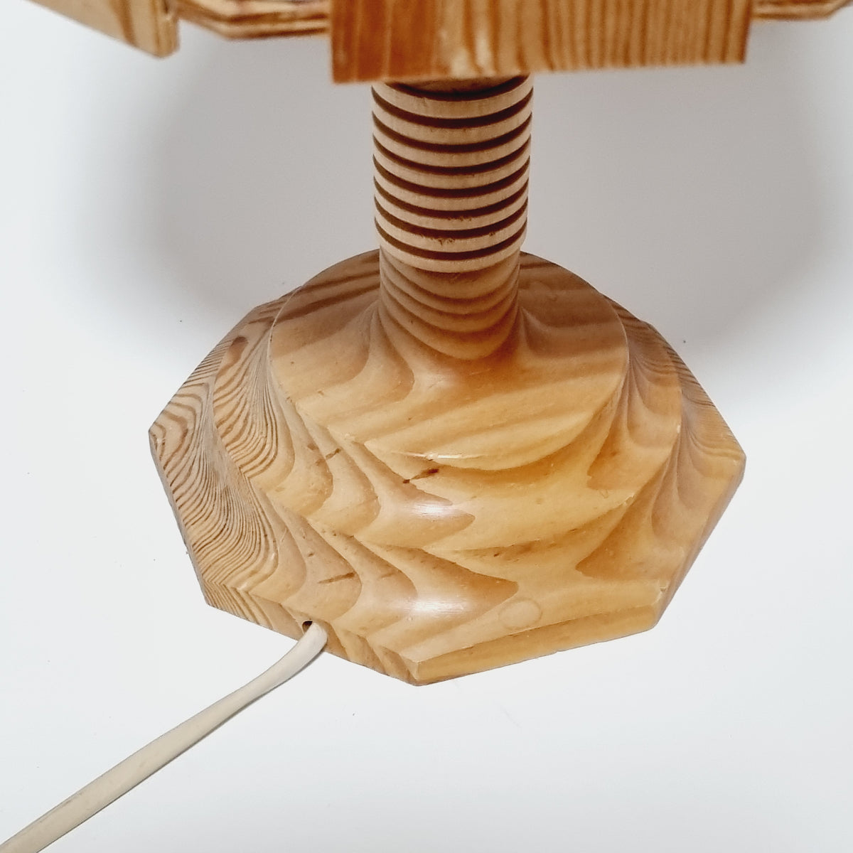 a wooden object with a curved, textured surface, possibly a piece of furniture or a decorative item.
