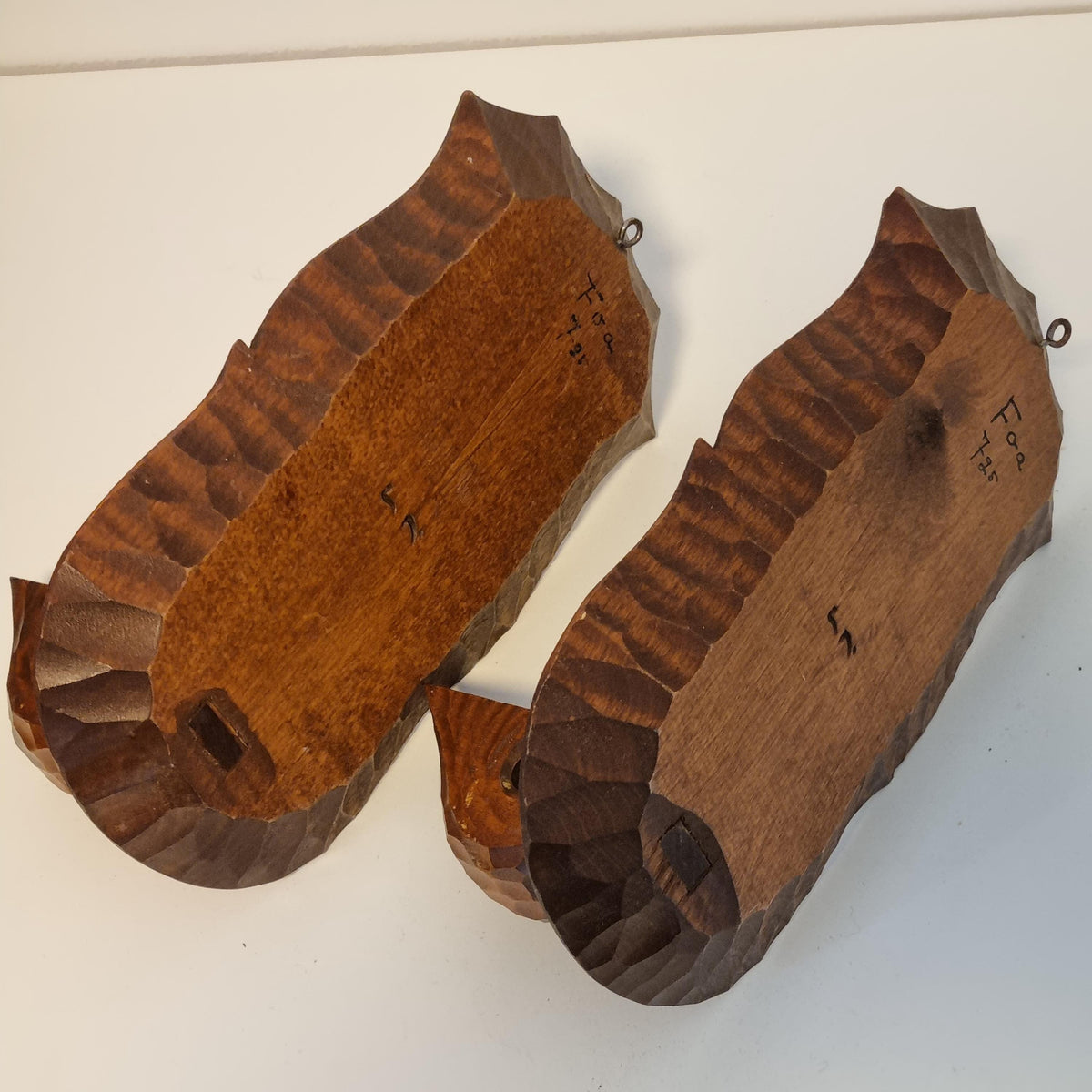 two wooden carved wooden objects, possibly a pair of wooden bowls or a similar type of wooden dish.