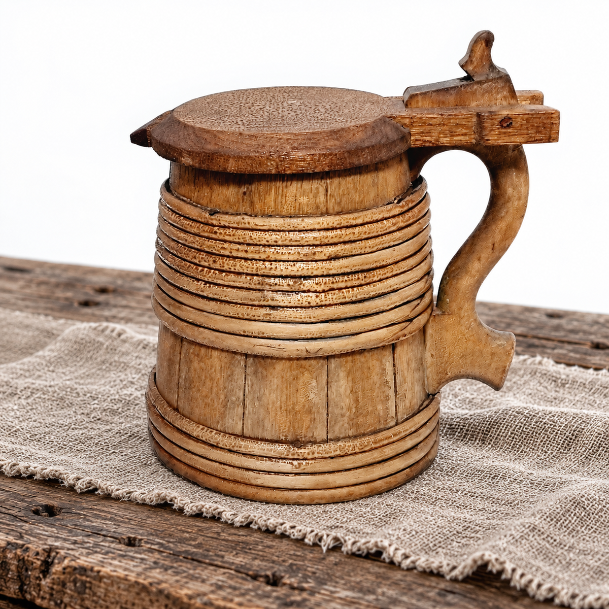 Staved wooden tankard with hinged lid styled on a table