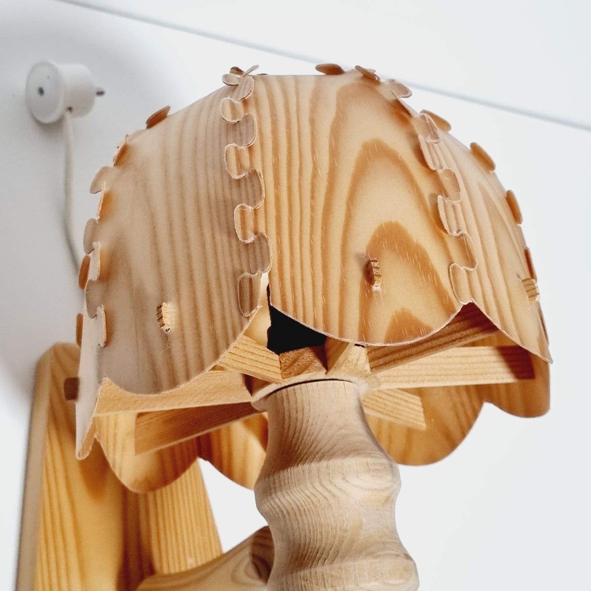 A wooden lamp with a wooden handle and a wooden base, featuring a wooden blade-like design.