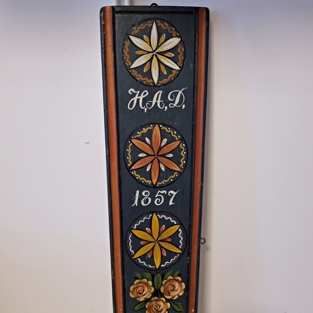 Hand painted rosettes and H.A.D. 1857 inscription on Swedish folk art wall hook