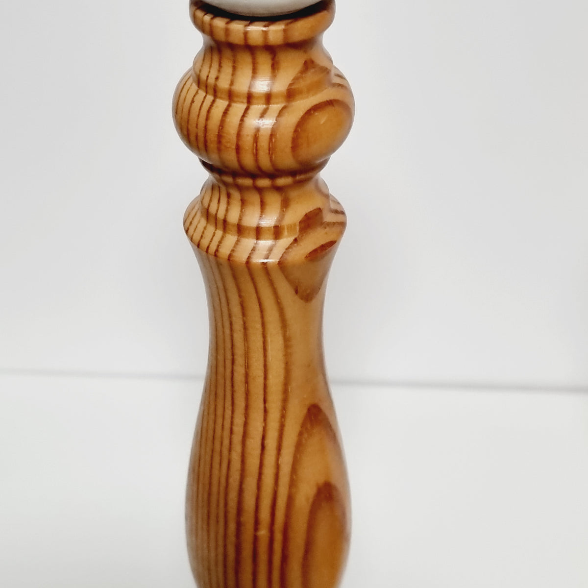 Close-up of rounded knop and pine grain on lamp stem