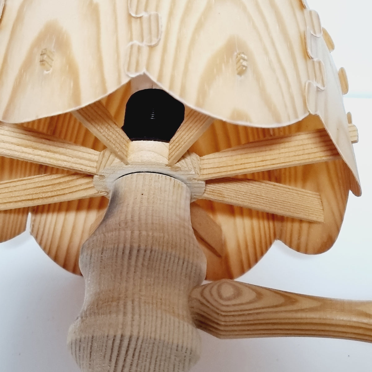 a wooden object with a curved, wooden handle and a black light bulb attached to it.