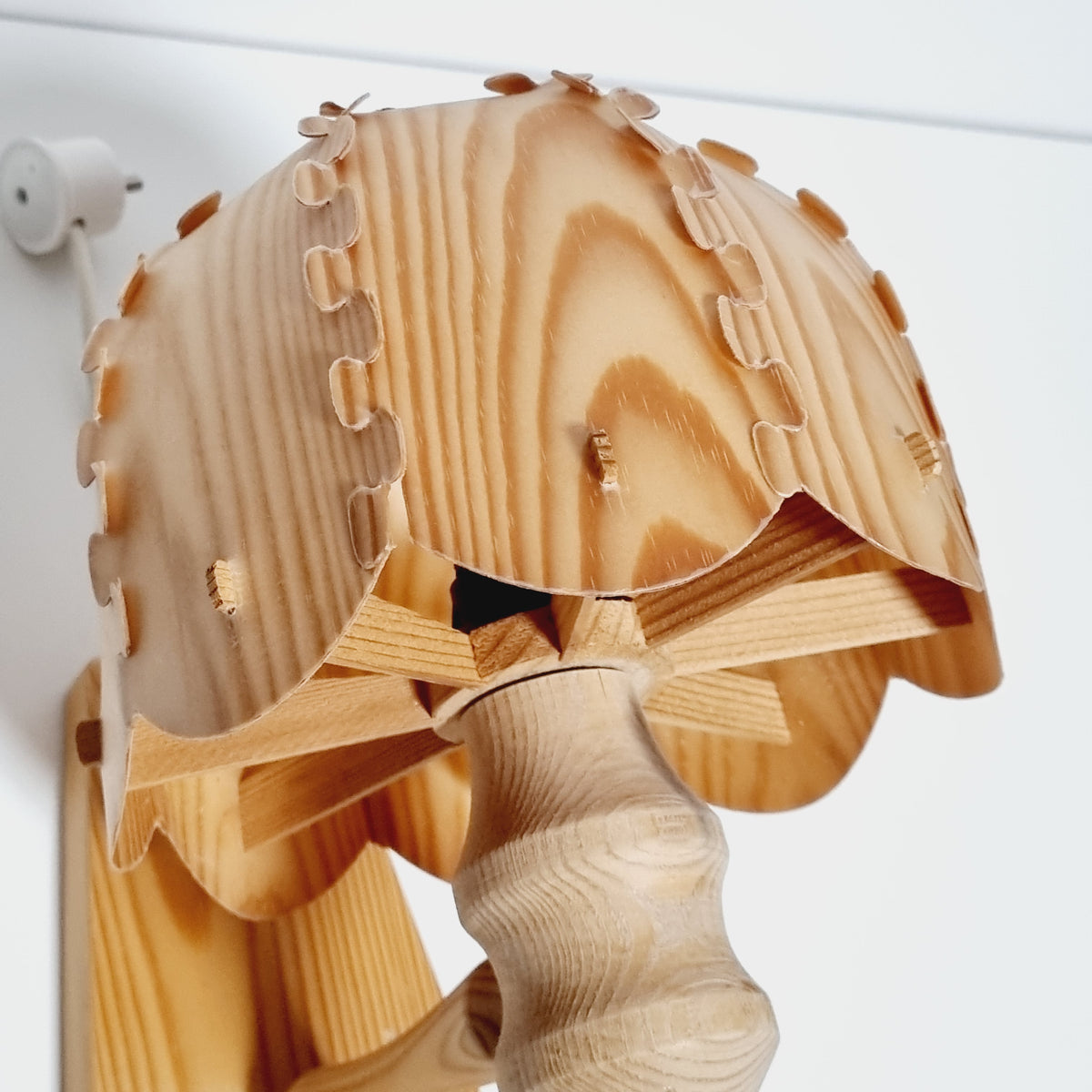A wooden lamp with a wooden handle and a wooden base, featuring a wooden blade or spindle-like structure.
