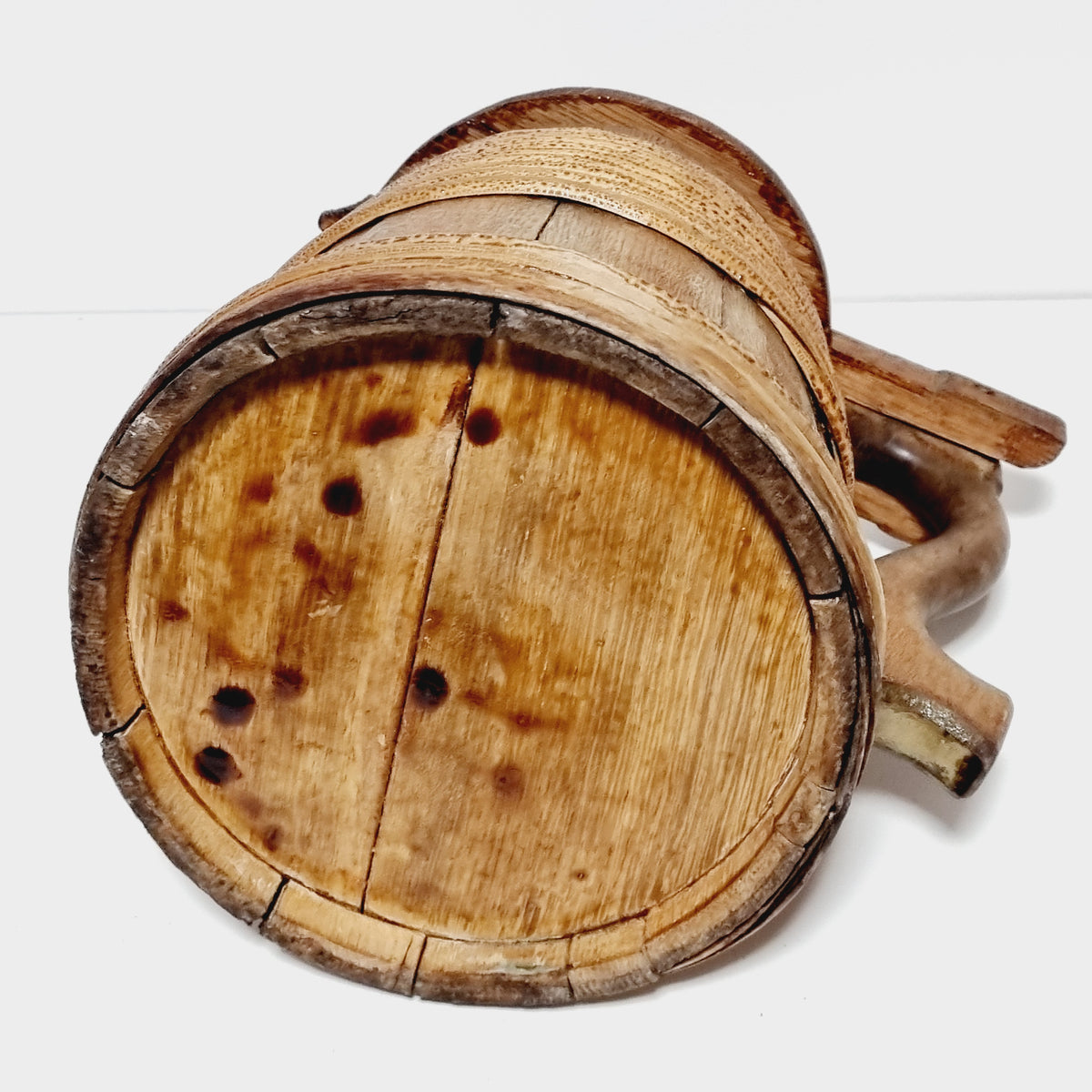 Antique staved tankard with carved thumb piece, side view