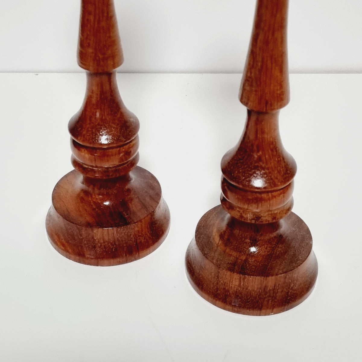 Pair of reddish-brown turned hardwood candlesticks, 23 cm tall