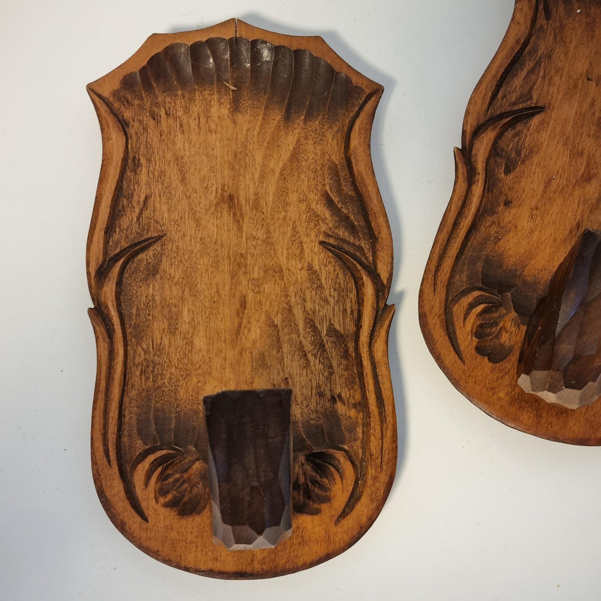 two wooden objects with intricate carved designs, including a large wooden plaque and a smaller wooden plaque.