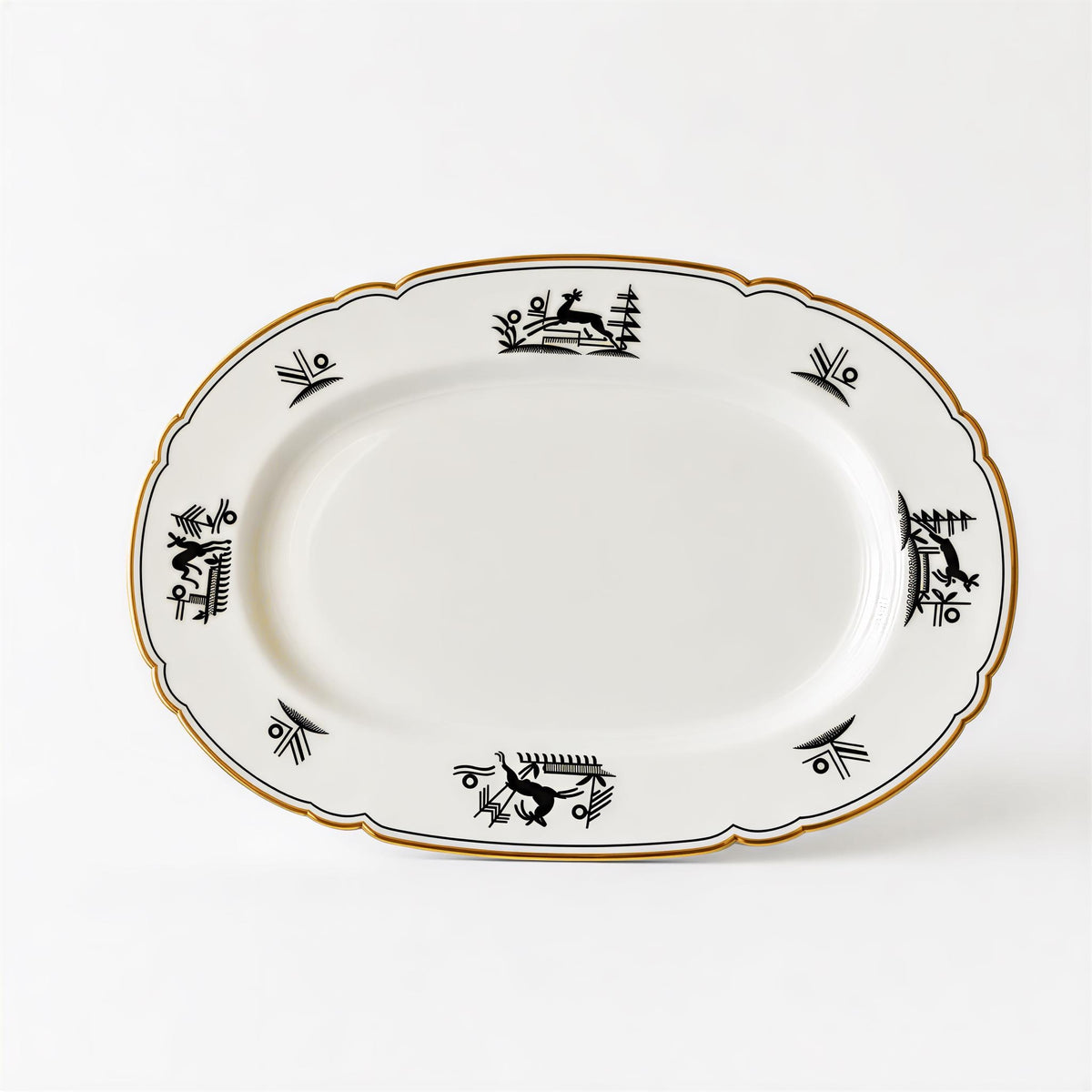 a white oval-shaped plate with a decorative border and black designs on it.
