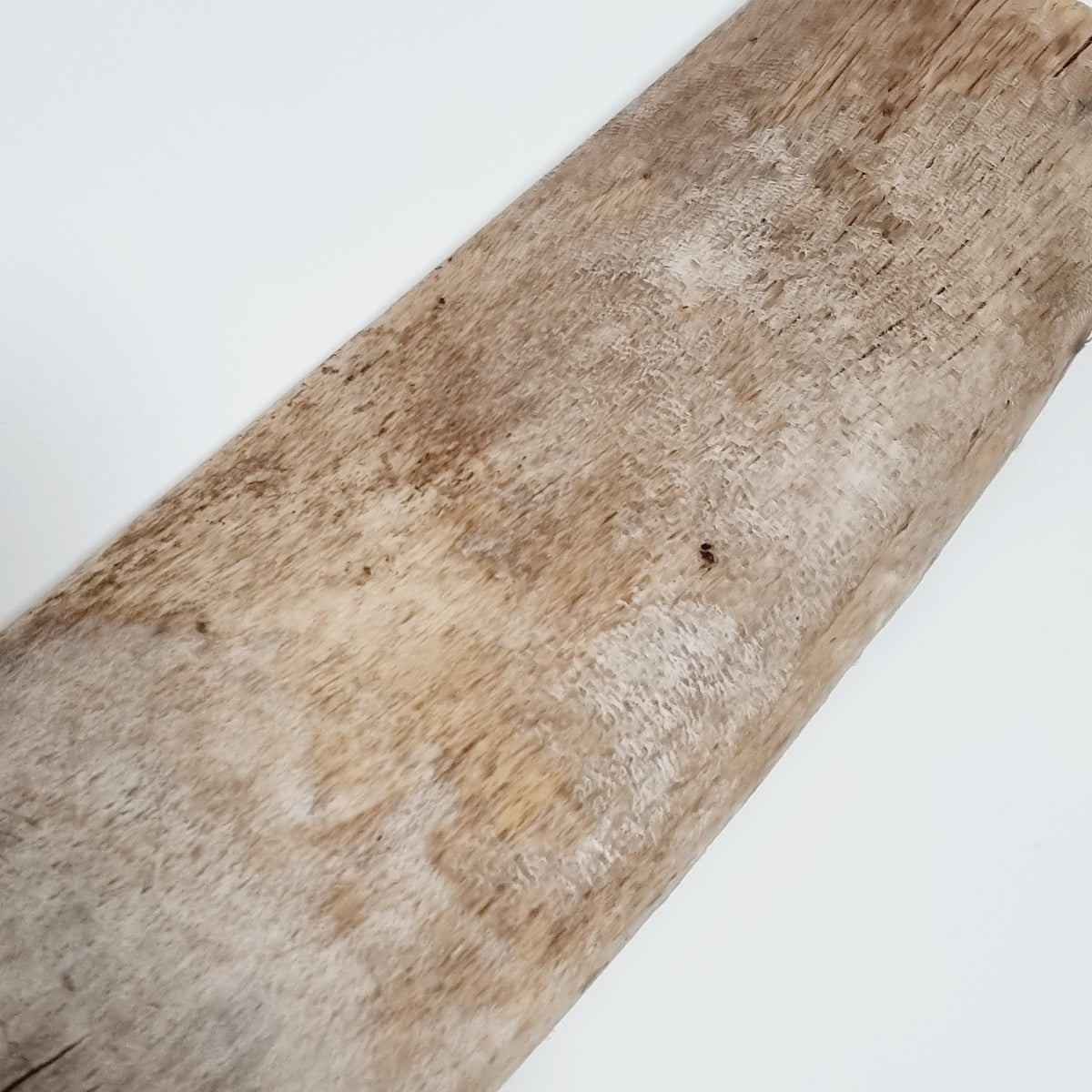 Close-up of cracks and weathered grain on the antique flax scutching knife blade