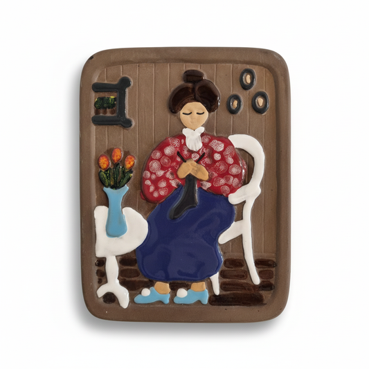Vintage Swedish Wall Plaque: Helsingborg Pottery Lady Deco 327 featuring a woman knitting in traditional dress with flowers on a table