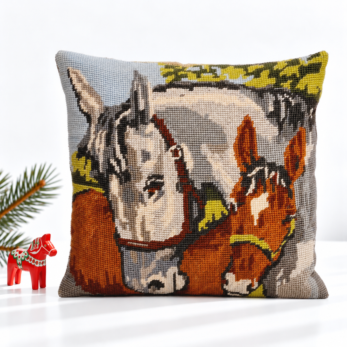 Mini horse needlepoint pillow styled with a red Dala horse and evergreen branch