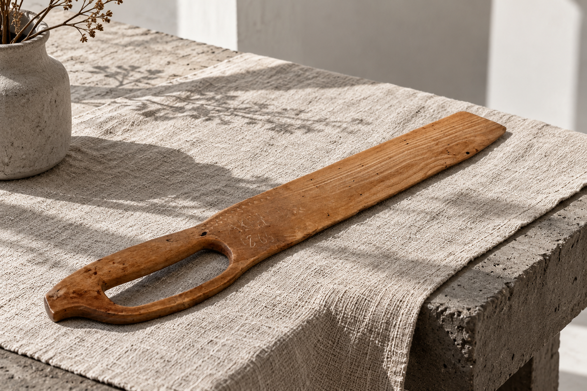 Antique Swedish flax scutching knife dated 1866 styled on a linen table runner