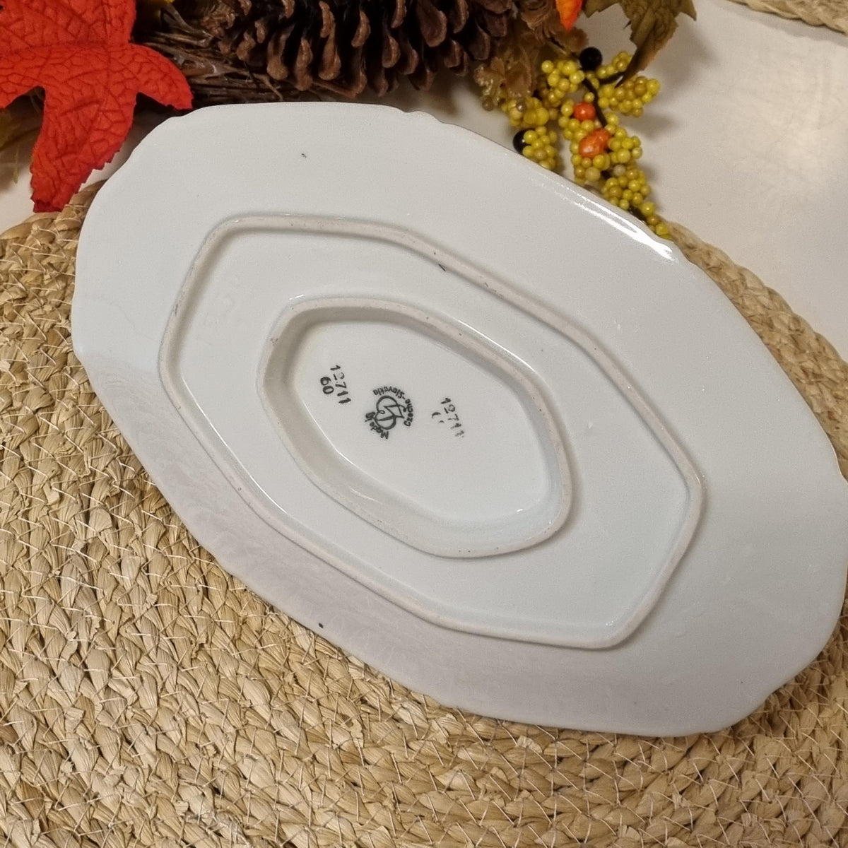 a white ceramic plate with a black logo on it, placed on a woven placemat.