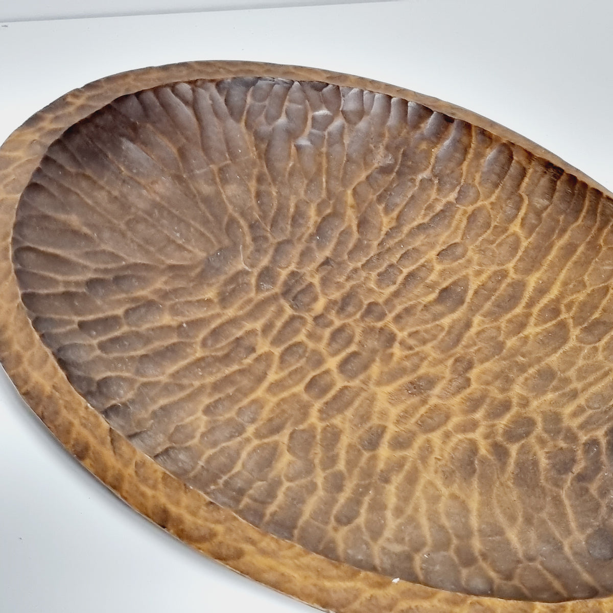Carved scroll handle curling into the wooden leaf dish
