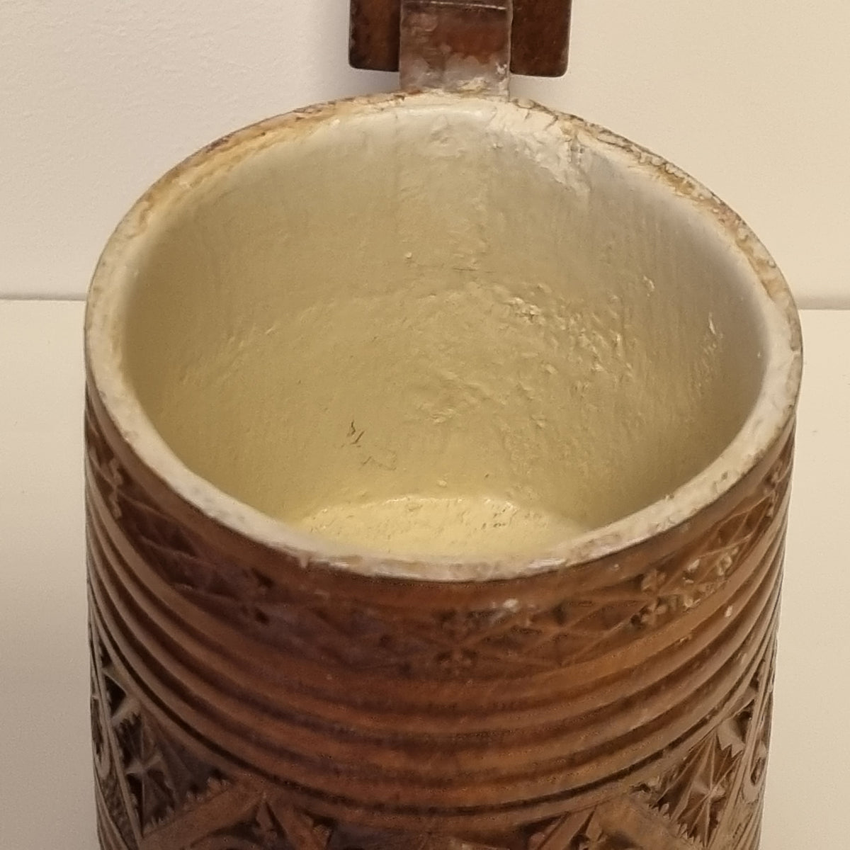 Close-up of chip carving with star rosettes and zigzag bands on wooden tankard