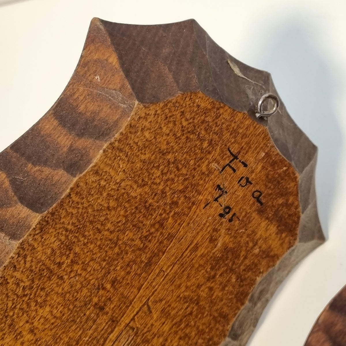 a wooden surface with a carved design and some writing or text on it.