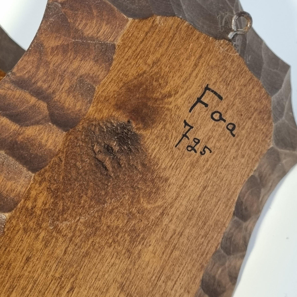 a wooden surface with a carved design and some text written on it.