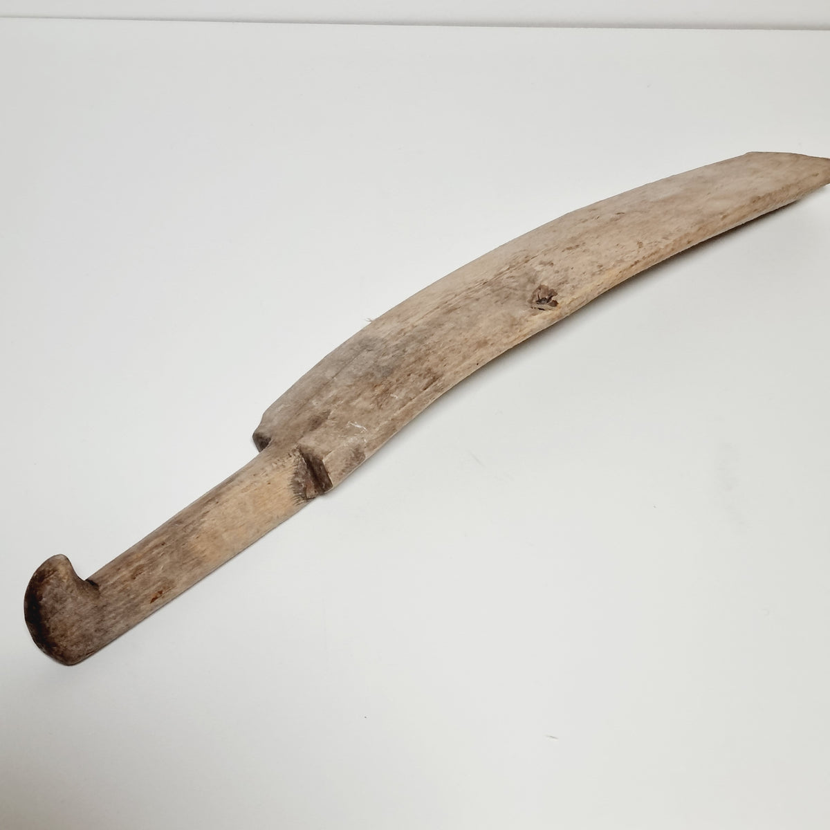Antique Swedish scutching knife showing the curved blade and natural knot