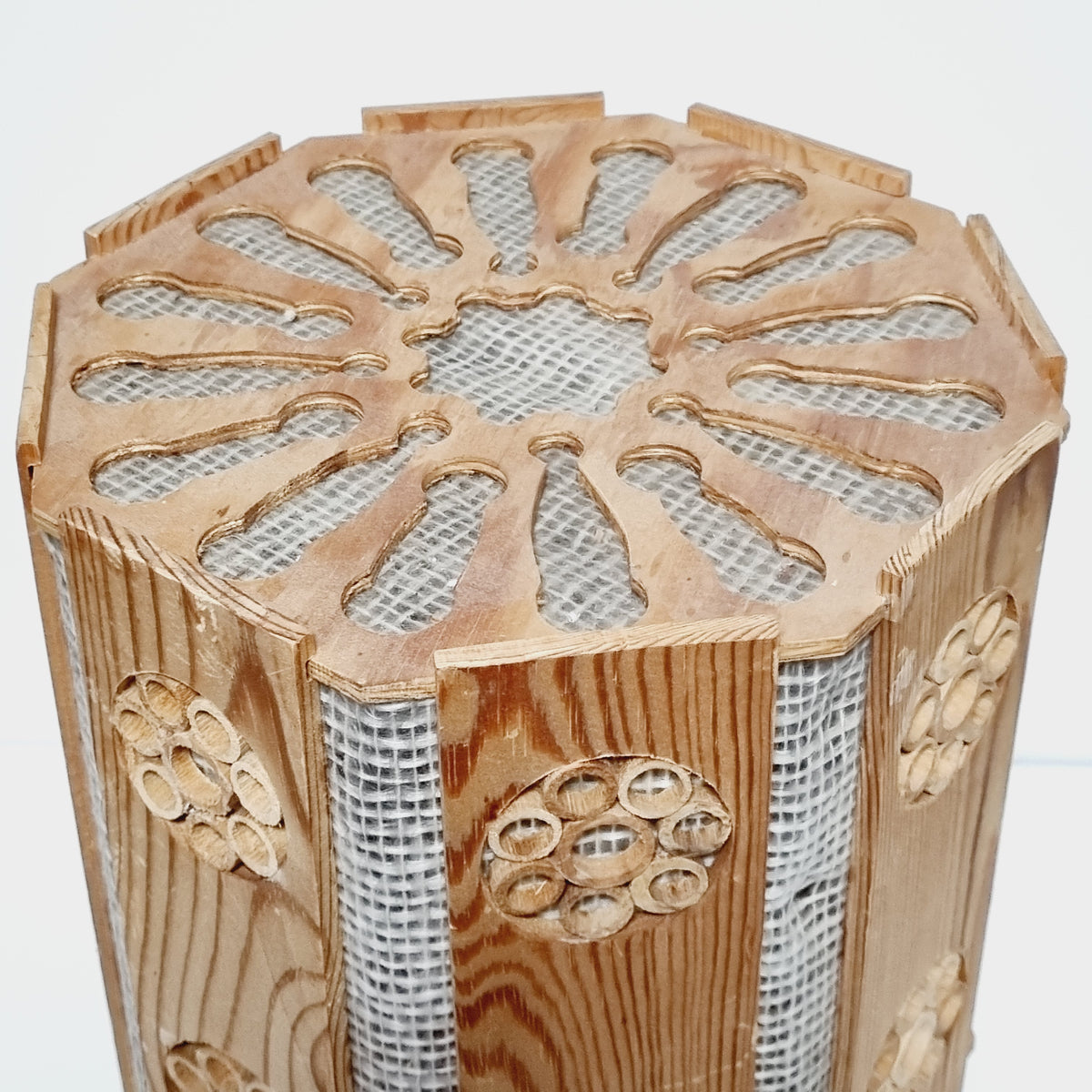 a wooden object with a unique, intricate design. The object has a circular pattern and is made of wood, with a mesh-like texture. The object appears to be a decorative piece, possibly a piece of art or a functional item.