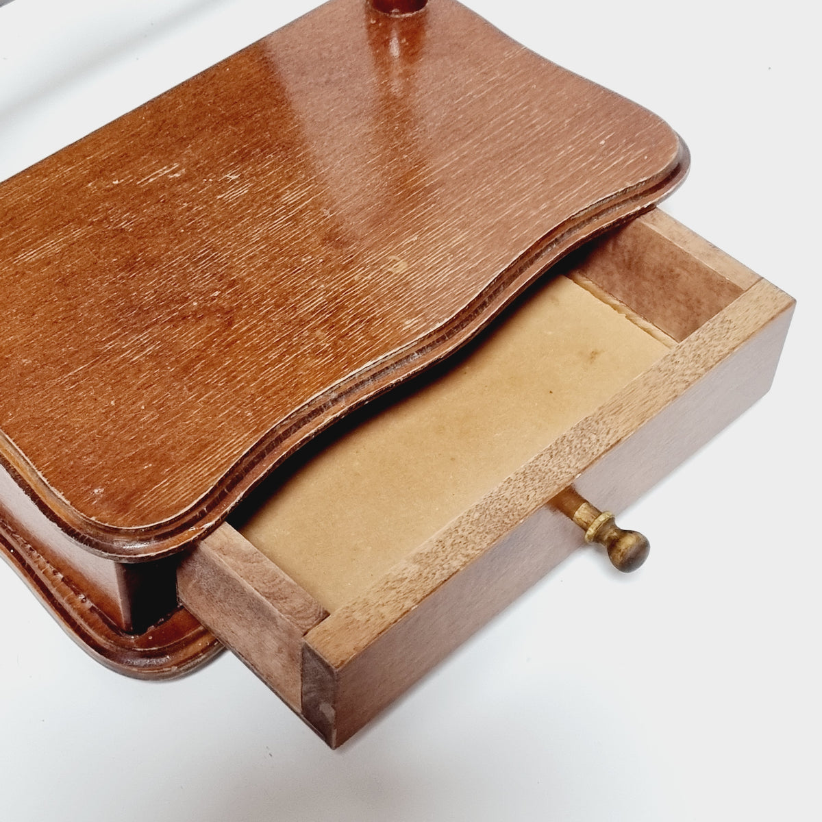 a wooden box with a wooden lid, revealing a wooden interior.