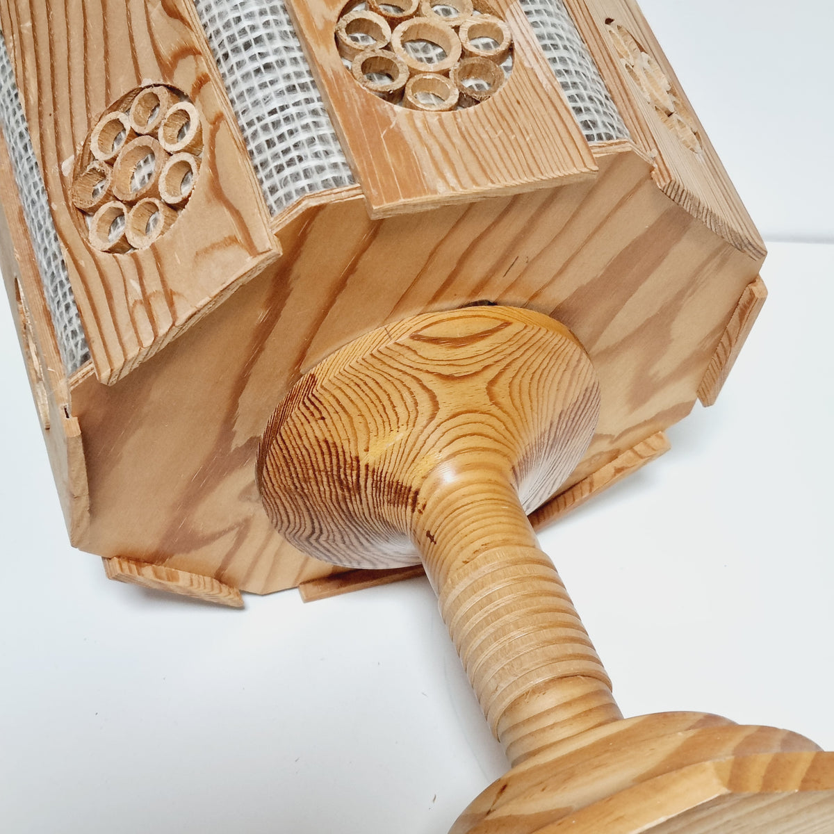 a wooden object with a textured surface, featuring a wooden handle and a circular design.