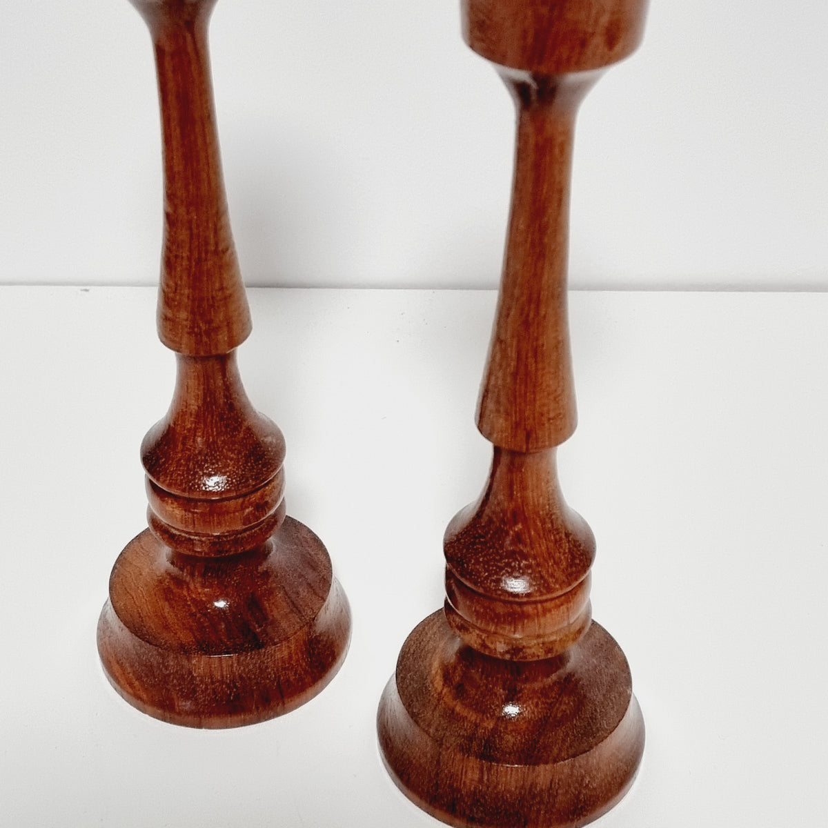 Ringed collars and stepped bases of turned wooden candlesticks