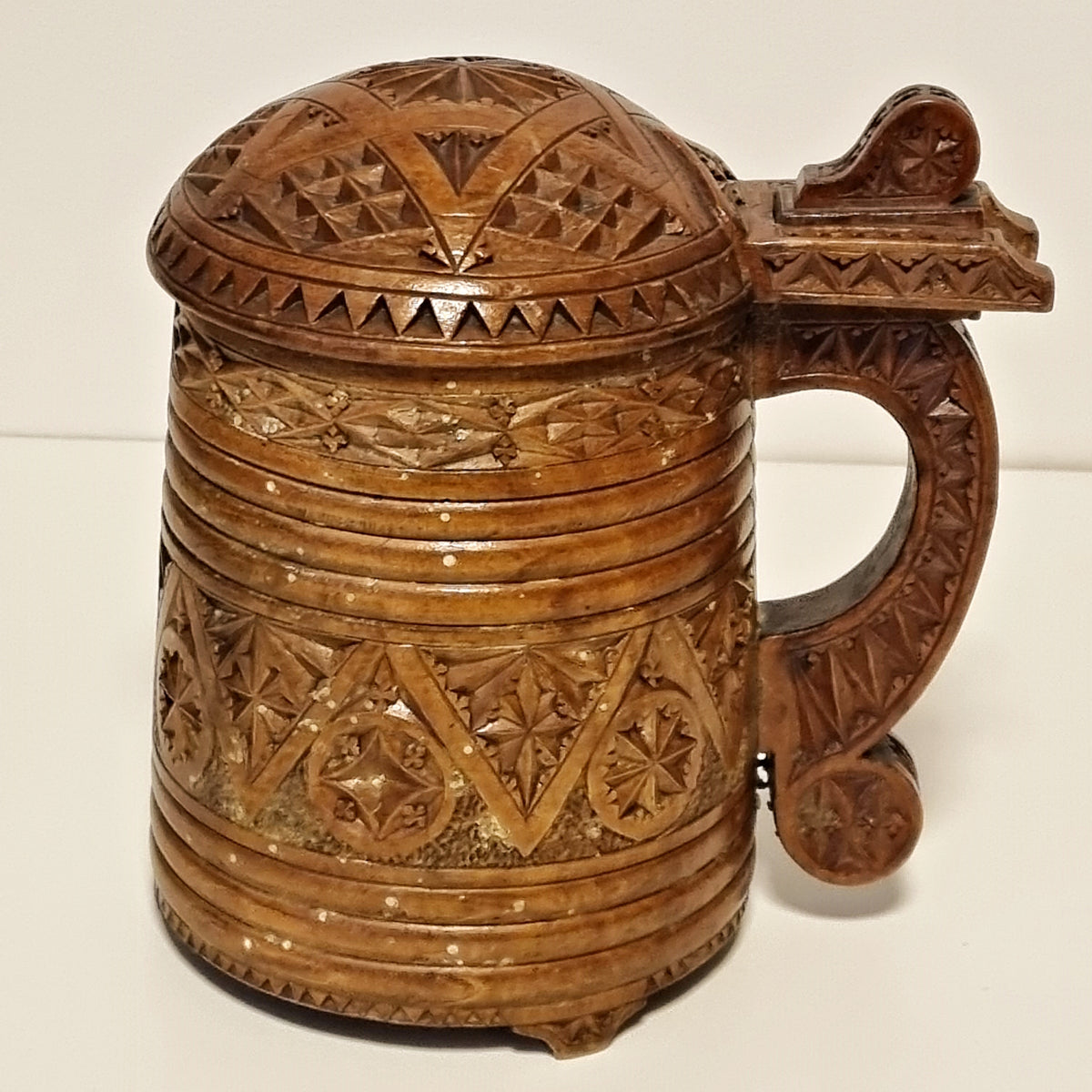 Geometric chip carving detail on antique Scandinavian wooden tankard