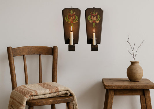 Vintage Hand-Painted Swedish Candle Sconces: Rustic Nordic Folk Art Pair mounted above wooden chair and table with vase.