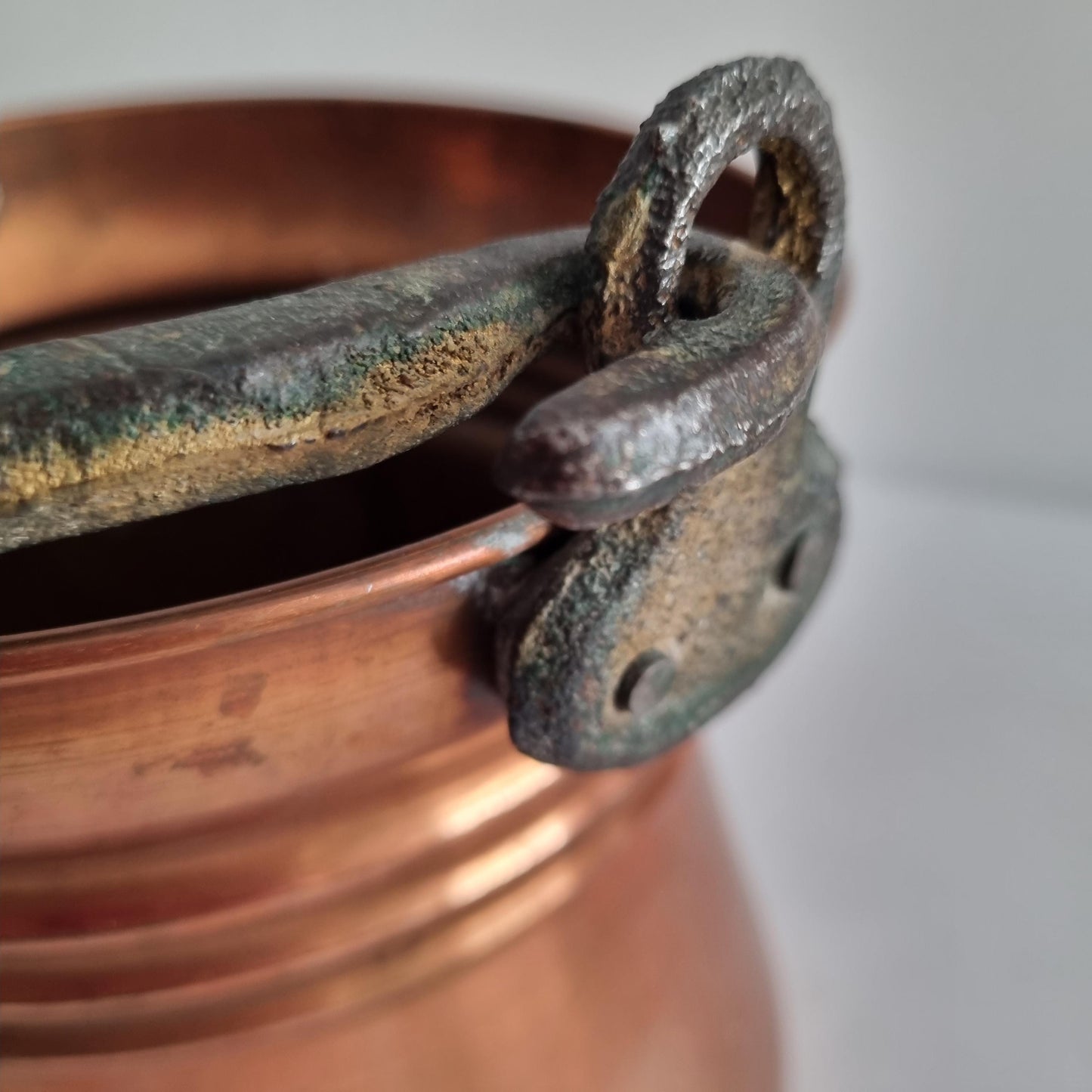 Close-up of the iron handle and rim on the Antique Copper Bucket: Rustic Farmhouse Cauldron with Iron Handle