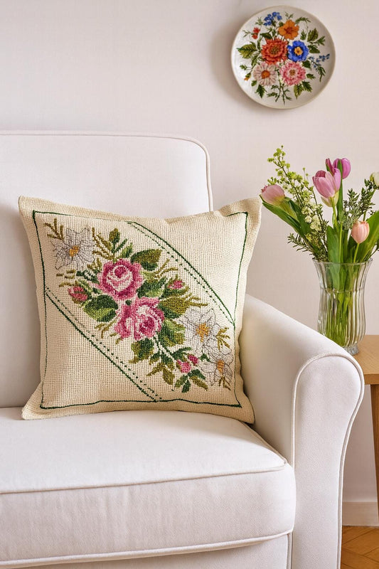 Vintage Hand Embroidered Pillow – Cross Stitch Cushion with Roses – Colorful Boho Home Decor on white armchair with flowers nearby