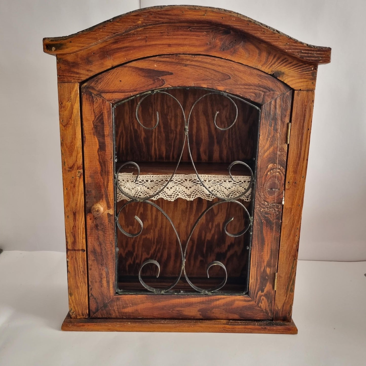 Antique Rustic Wood Wall Cabinet with Iron Door: Farmhouse Kitchen Storage featuring decorative metal scrollwork and lace shelf lining.
