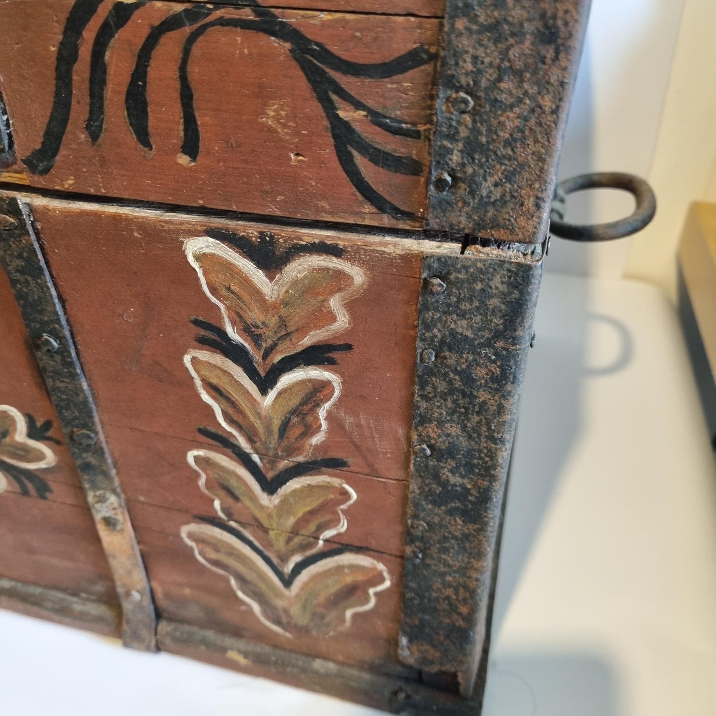 Close-up detail of painted folk art design on Antique Swedish Kurbits Chest: 1854 Dalarna Folk Art Painted Trunk with metal hardware