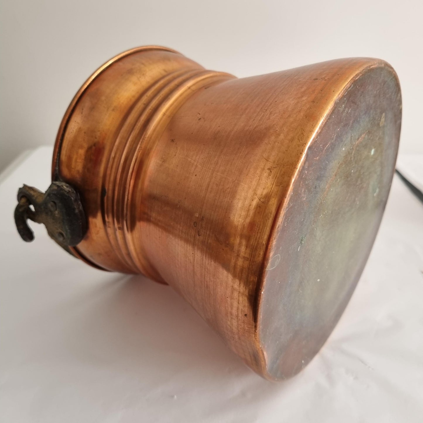 Antique Copper Bucket: Rustic Farmhouse Cauldron with Iron Handle lying on its side showing copper patina and iron handle detail