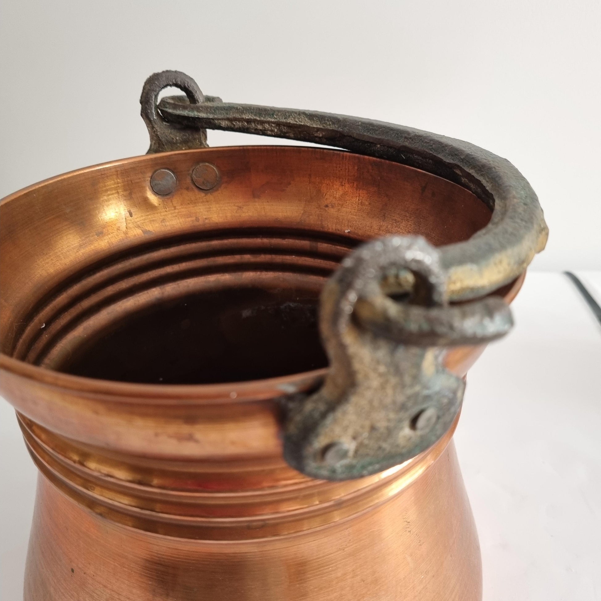 Antique Copper Bucket: Rustic Farmhouse Cauldron with Iron Handle showing patina and aged copper texture close-up view.