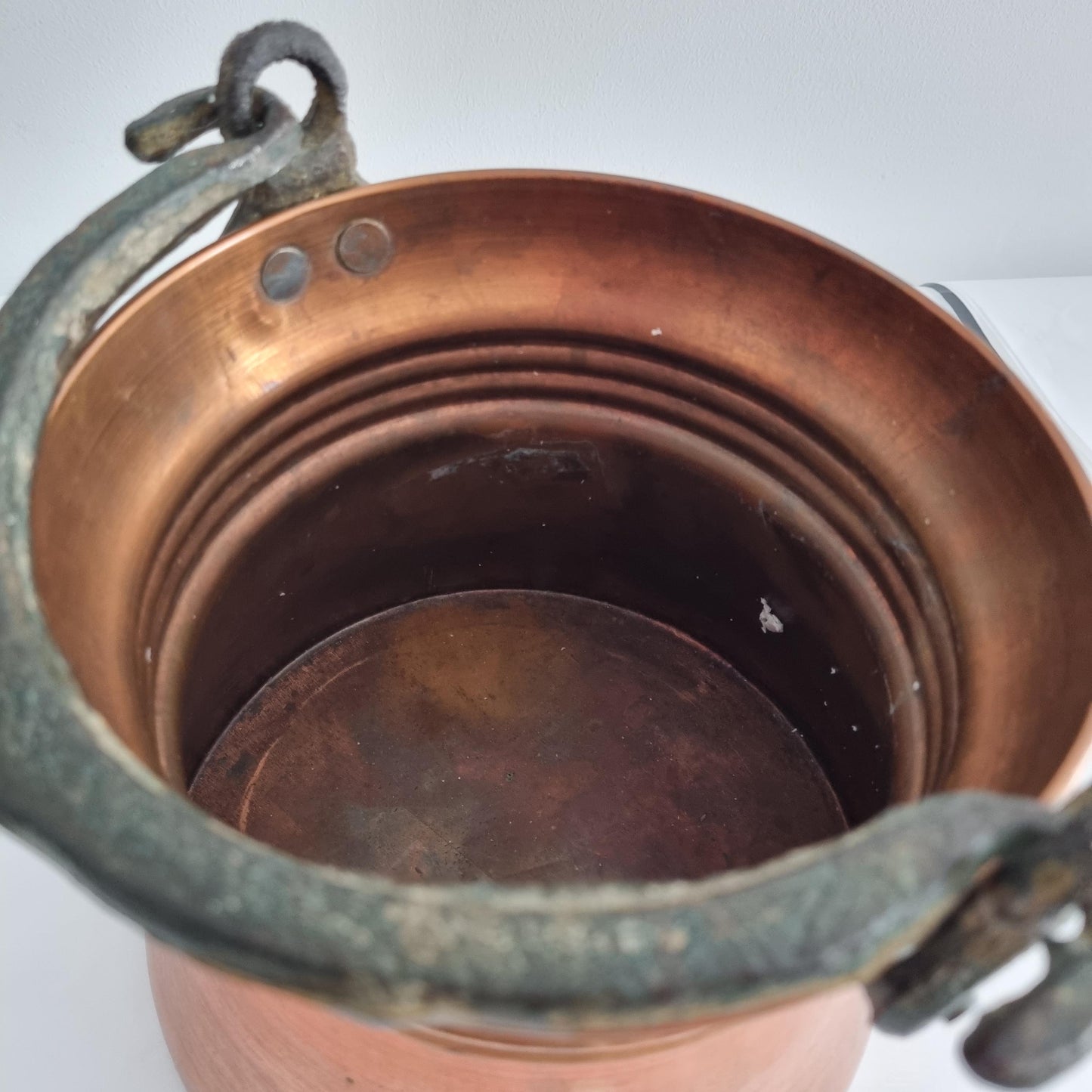 Antique Copper Bucket: Rustic Farmhouse Cauldron with Iron Handle showing worn copper interior and sturdy iron handle close-up